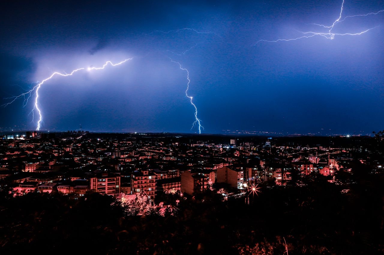services-01 Dramatic night cityscape with vivid lightning illuminating the skyline.