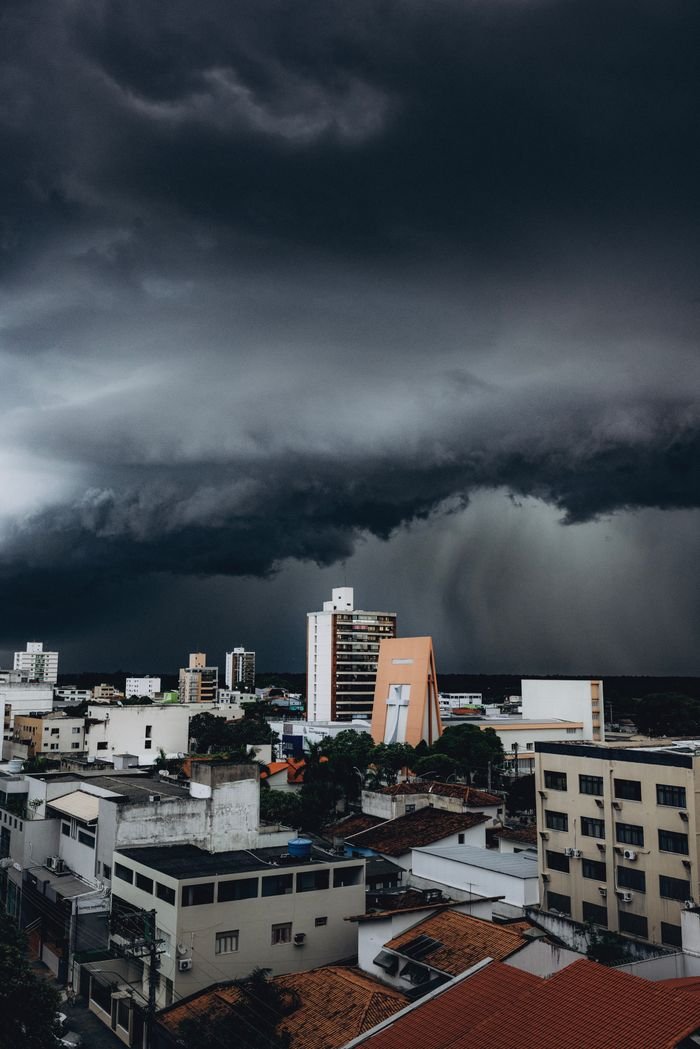 Mastering the First Impression: Your intriguing post title goes here Dark storm clouds loom over a cityscape, highlighting the contrast between nature and urban life.
